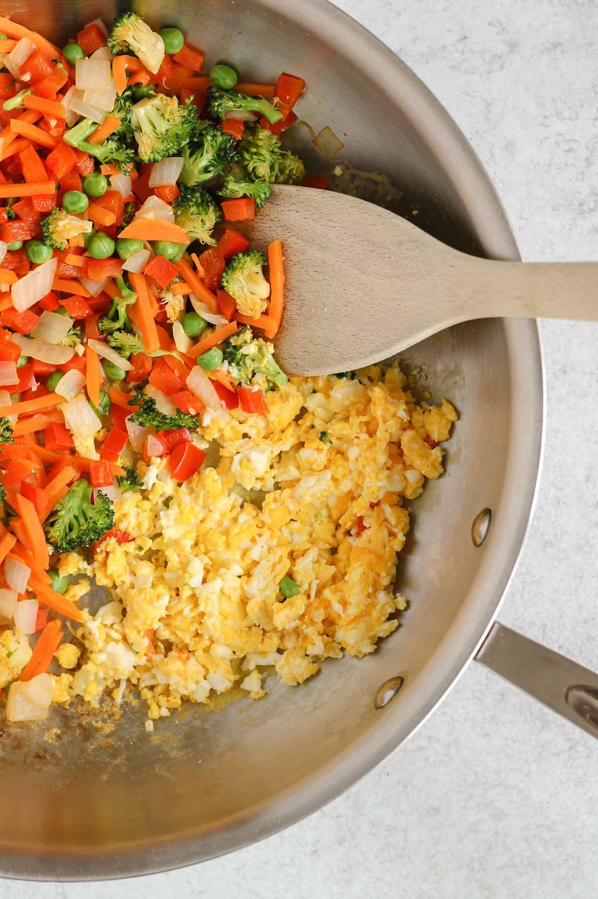 Sauteed fried rice veggies and scrambled eggs in a cast iron skillet.