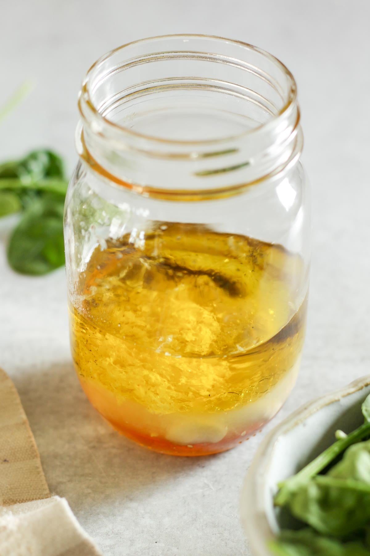 Ingredients for lemon honey dressing added to a mason jar.