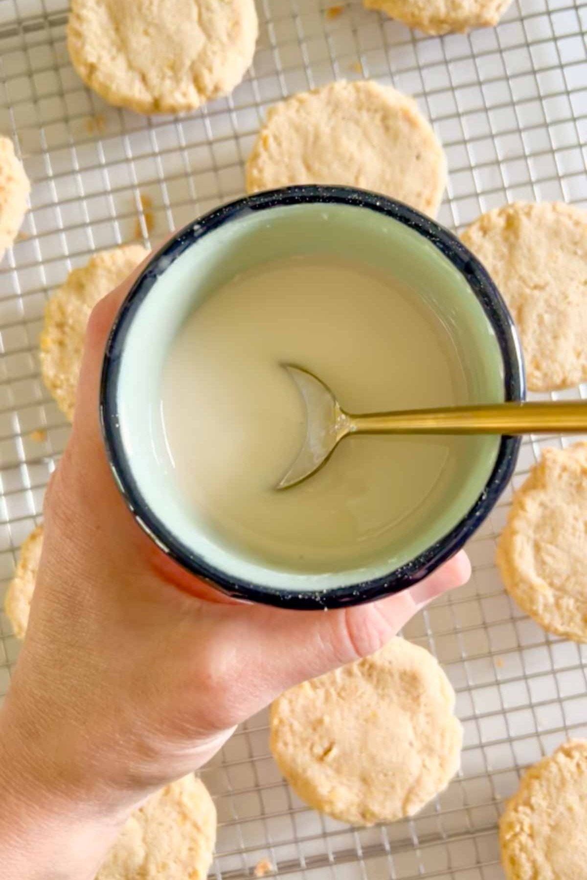 Powdered sugar glaze mixed in a small bowl with a spoon in the bowl.