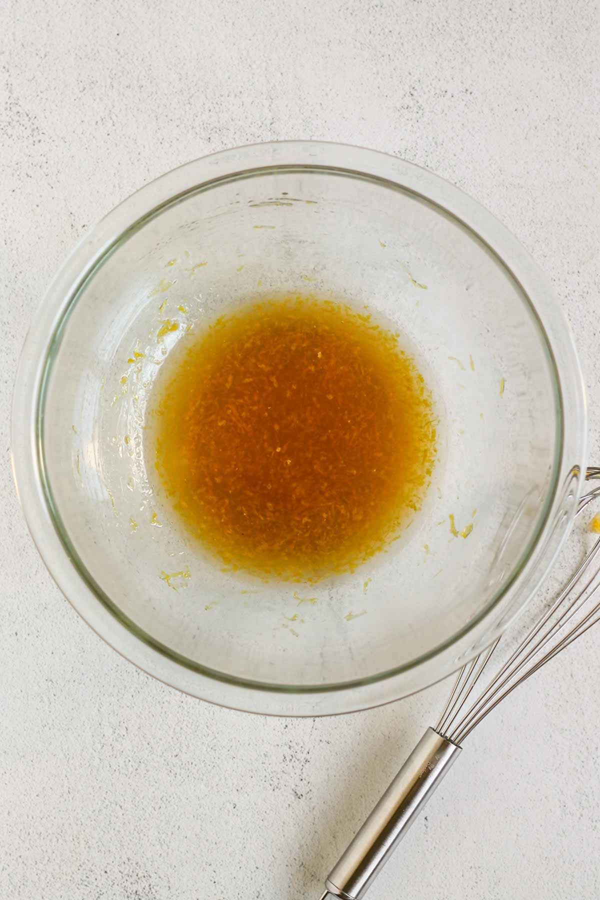 Almond flour cookie wet ingredients whisked in a glass mixing bowl.