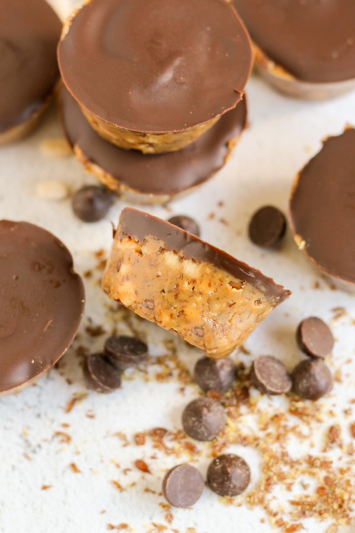 Peanut butter crispy bite laid on it's side with additional bites set on the outside and chocolate chips sprinkled throughout.