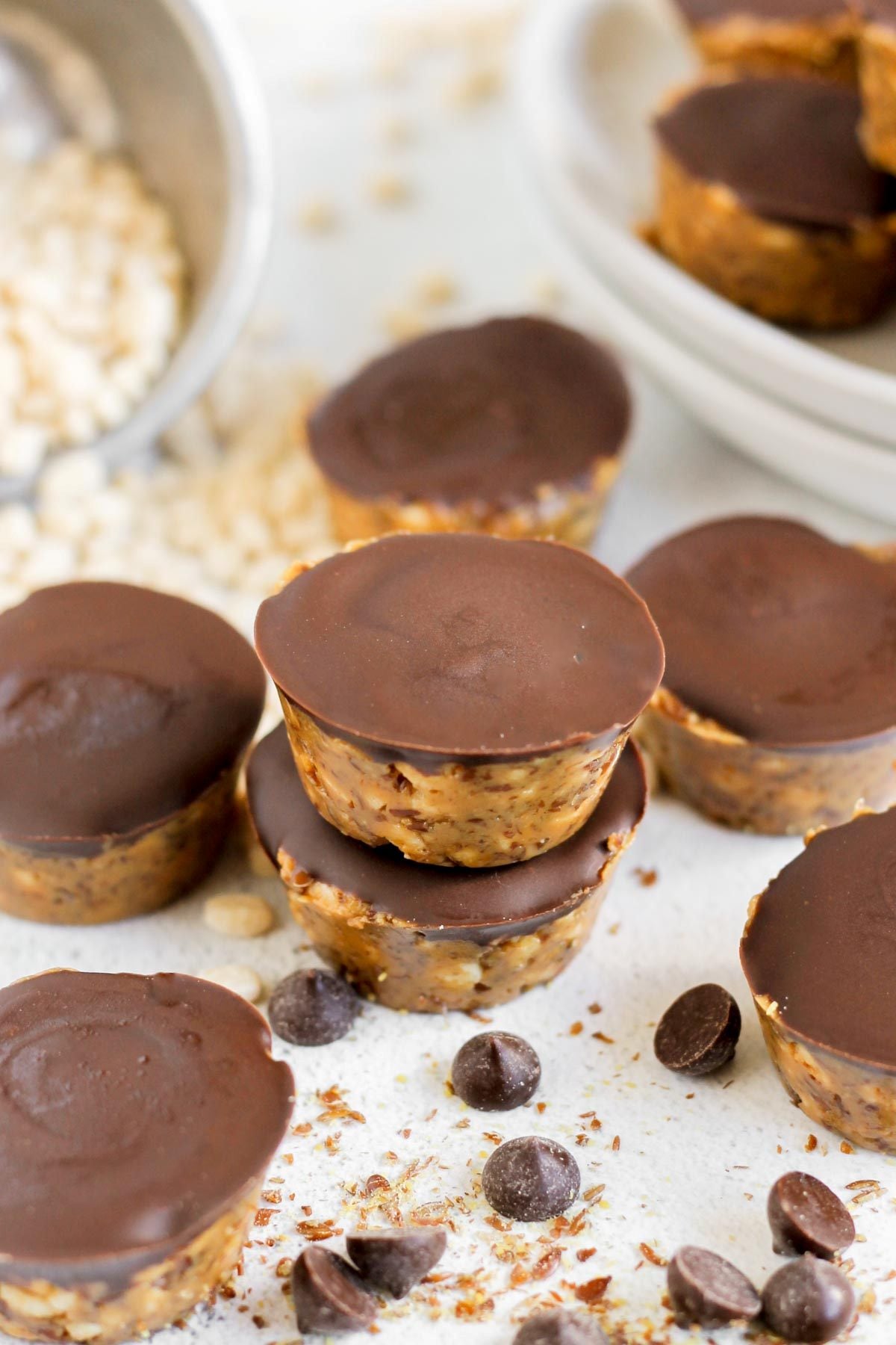 Peanut butter crispy bites spread out on a flat surface with chocolate chips sprinkled throughout.