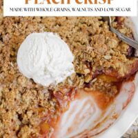 Peach crisp topped with ice cream in a pie plate with some scooped from the corner. Text overlay "Healthy summer peach crisp. Made with whole grains, walnuts and low sugar."