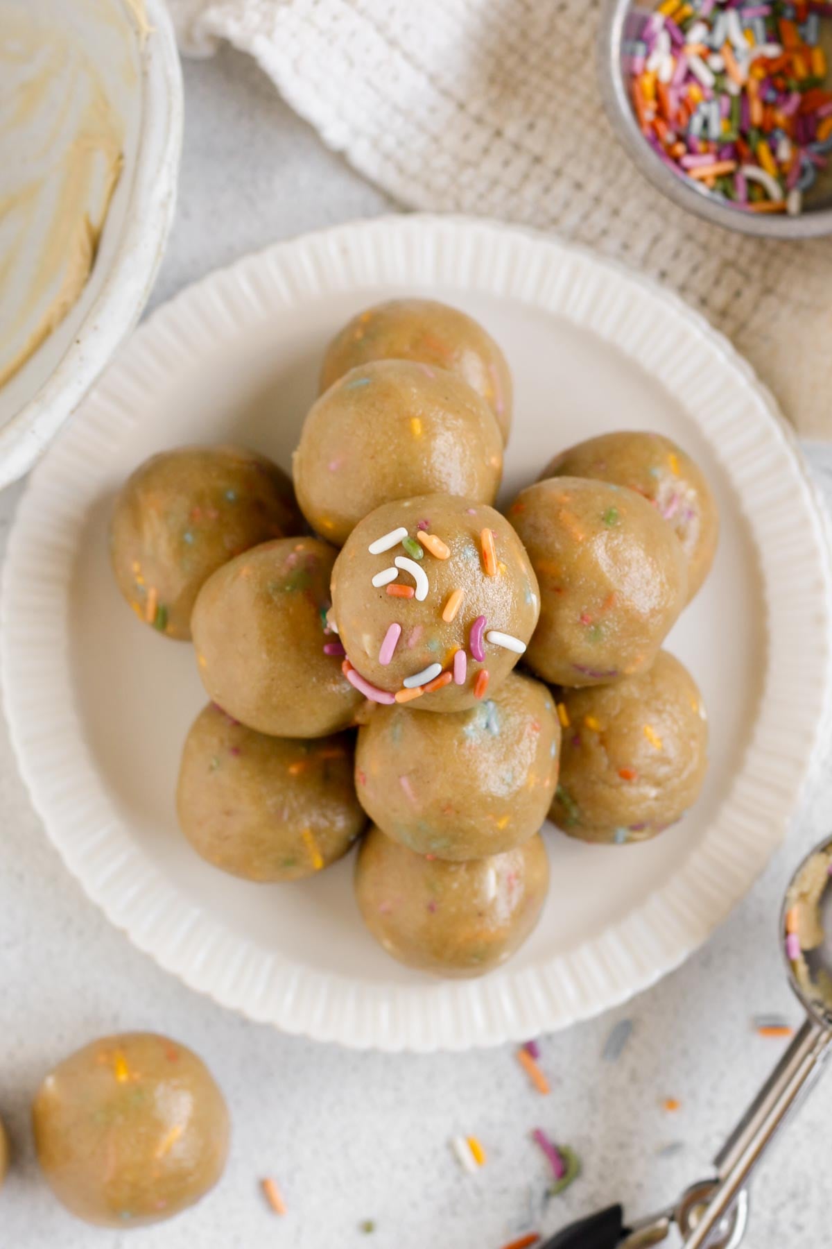 Birthday cake protein balls stacked on a small plate.