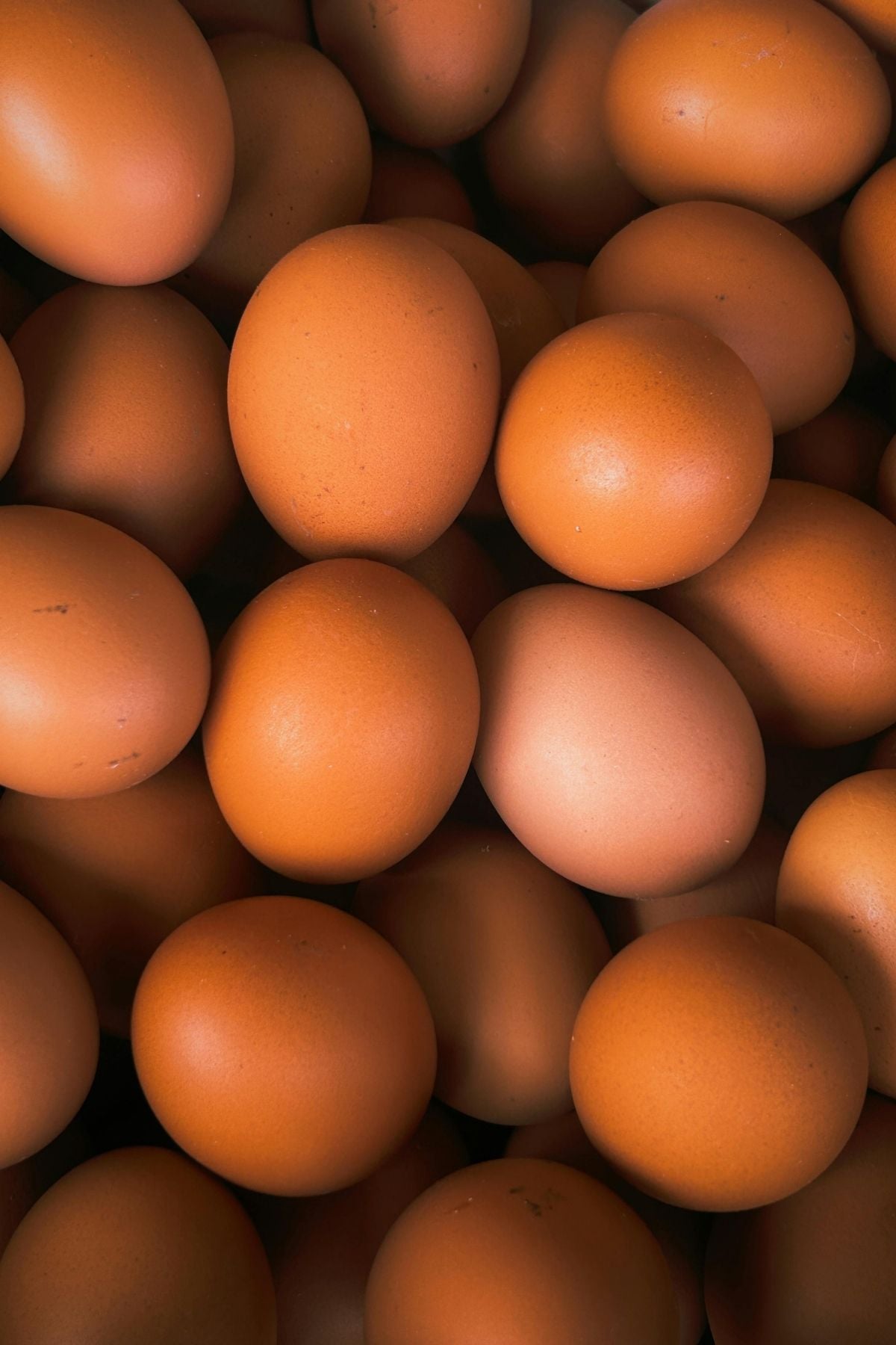 Brown eggs stacked laying on top of one another.