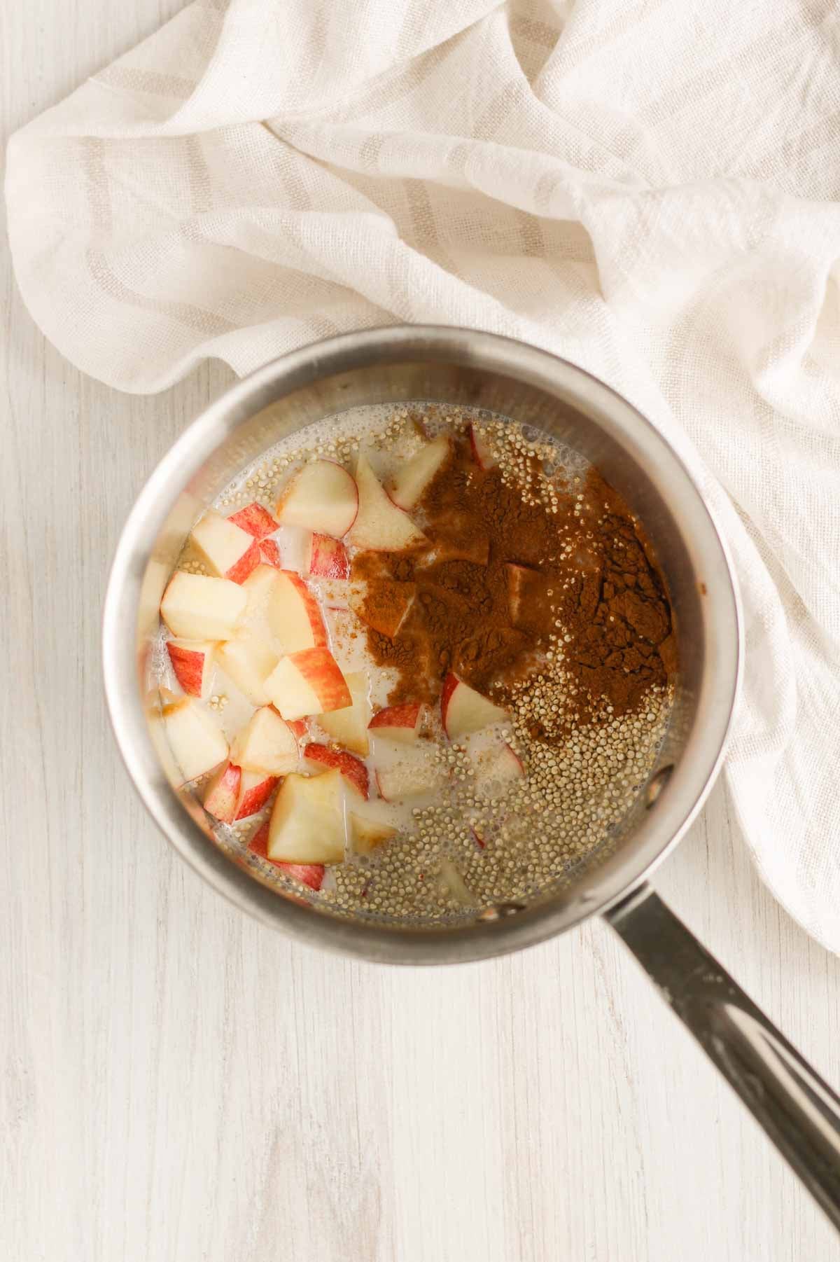 Quinoa, milk, chopped apples and cinnamon in a small stainless steel sauce pan.