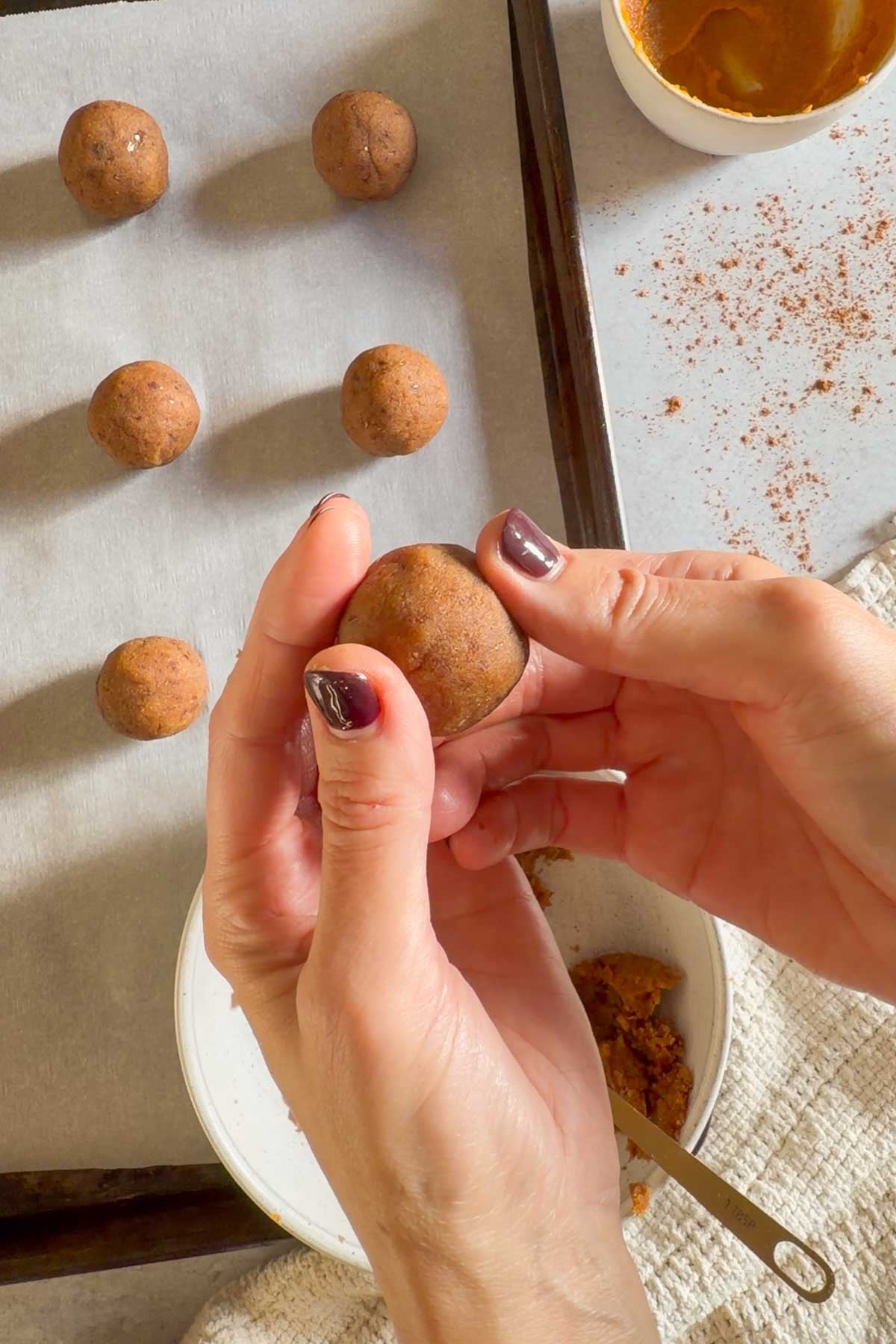 Pumpkin pie truffles dough being rolled into balls.