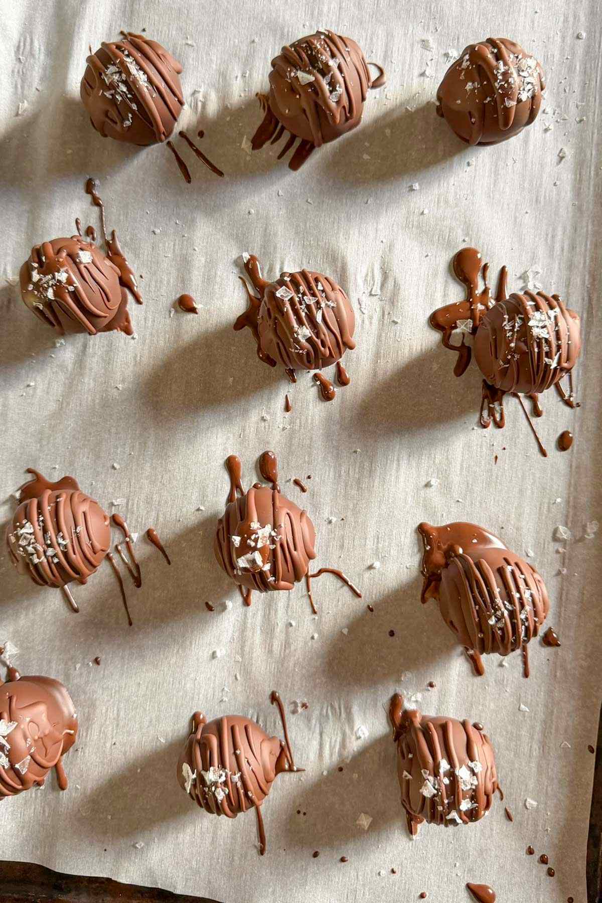 Pumpkin pie truffles drizzled with chocolate and sprinkled with sea salt.