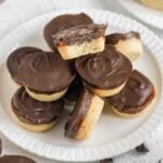 Small round Twix bites stacked on a small plate with a bite taken from the top Twix bite.