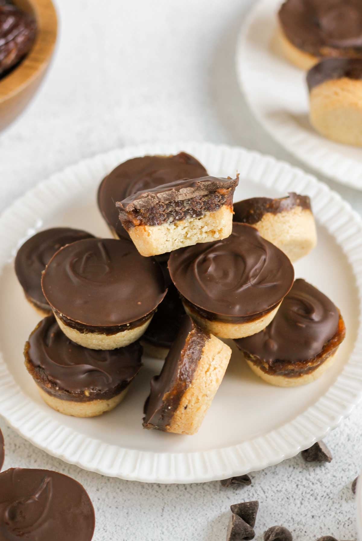 Small round Twix bites stacked on a small plate with a bite taken from the top Twix bite.